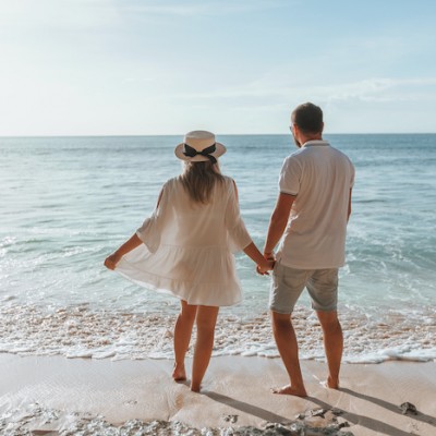 Couple Hold Hands On Beach