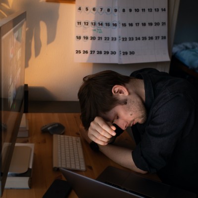 Sad Man Leaning On Desk