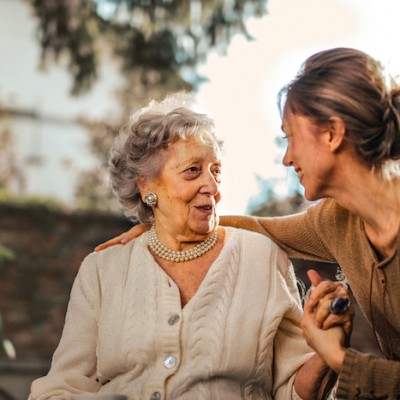 Senior Citizen With Young Woman Talking