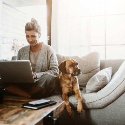 Woman On Computer Next To Dog