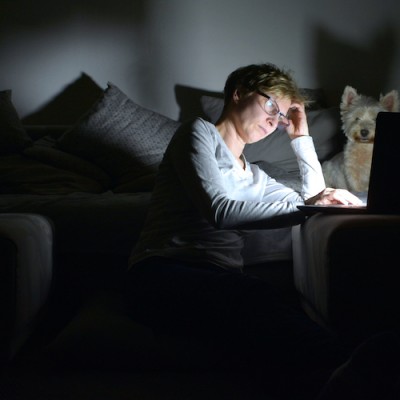 Woman Sitting In Darkness With Laptop